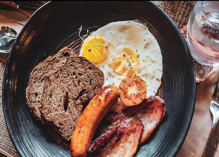Burrow Cafe Breakfast with toast, eggs, banana, and slabs of bacon