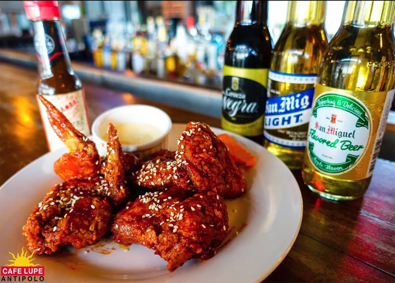 Buffalo wings topped with sesame seeds paired with an assortment of beers from Cafe Lupe