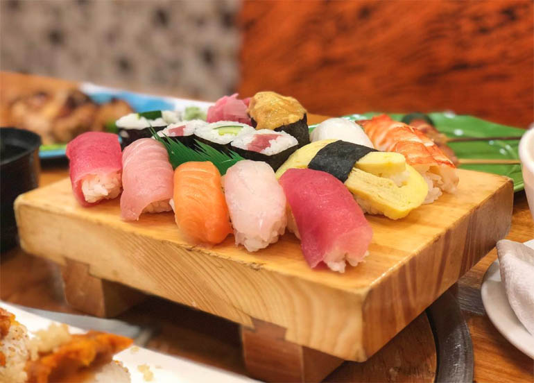Nihonbashi Tei's Chirashi meal served on a wooden board filled with an assortment of maki and sushi
